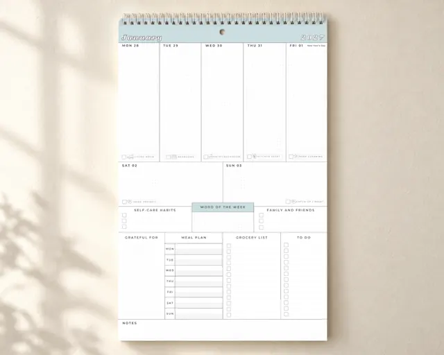 The Organized Mom Collective weekly wall calendar hanging on a wall.